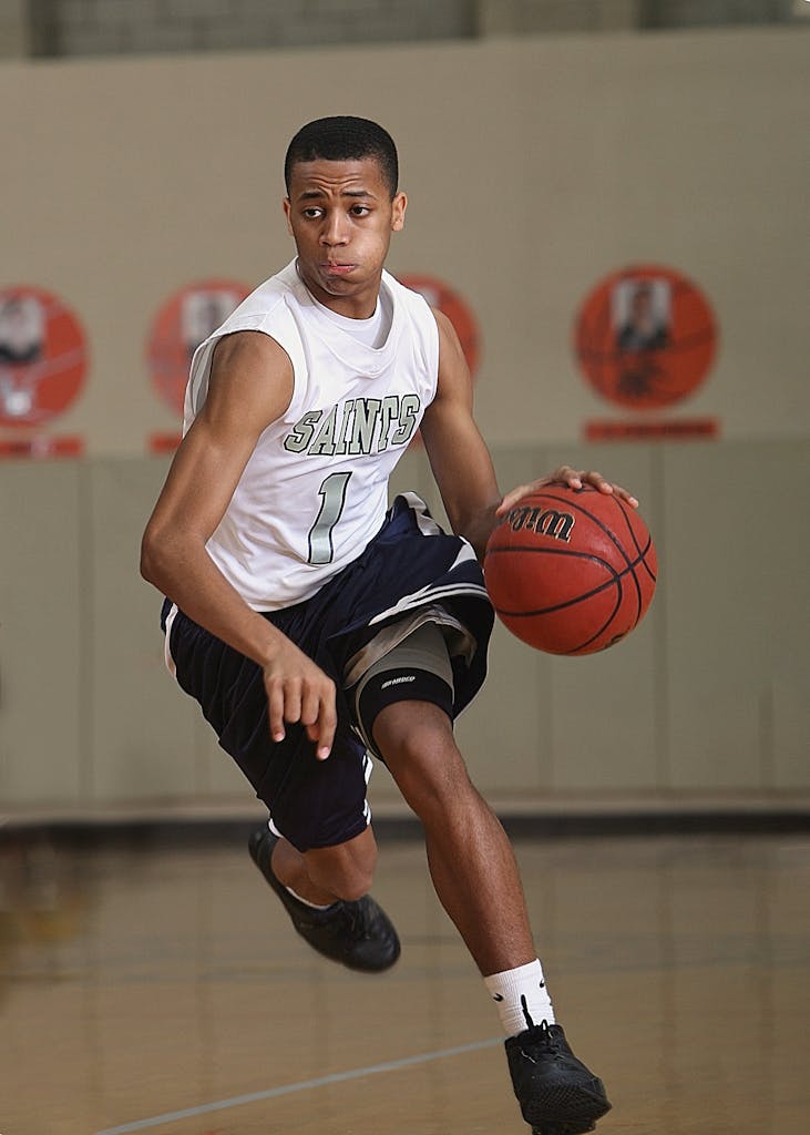 Energetic basketball player in mid-dribble on an indoor court.